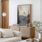 A minimalist living room showcases the Frosted Ascent Canvas Art - Vertical above a light wood sideboard, styled with neutral vases, stacked books, and a small plant next to a white sofa with cream cushions.