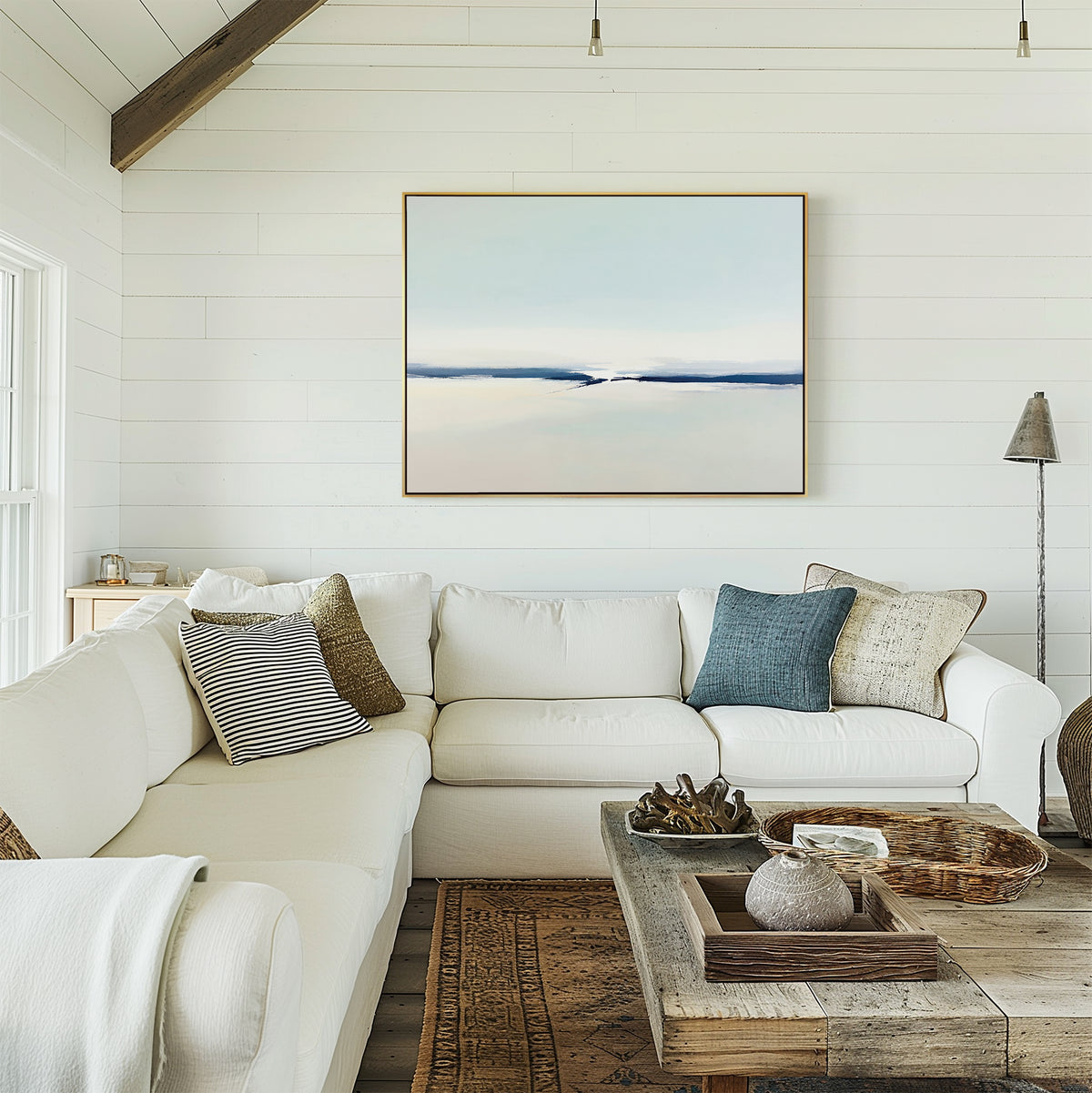 A cozy living room with a white sectional sofa, assorted throw pillows, a rustic wood coffee table, stylish trays and vases, a floor lamp, and modern decor featuring the Frozen Channel Canvas Art - Horizontal on a white shiplap wall.