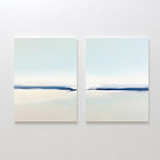 Frozen Channel - Set Of 2 features minimalist wall art with soft, blurred horizontal bands of light blue, white, and beige—ideal serene prints for modern living room decor against a white wall.