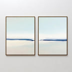 Frozen Channel - Set Of 2 features minimalist art prints with soft cream and light blue gradients, accented by a dark blue horizontal line. Simple, thin frames complete this serene decor set, ideal for modern living rooms.