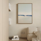 A minimalist living room corner features a beige sofa, built-in bookshelves, and the Frozen Channel Canvas Art - Vertical in calming blue tones as modern wall decor above an electrical outlet.