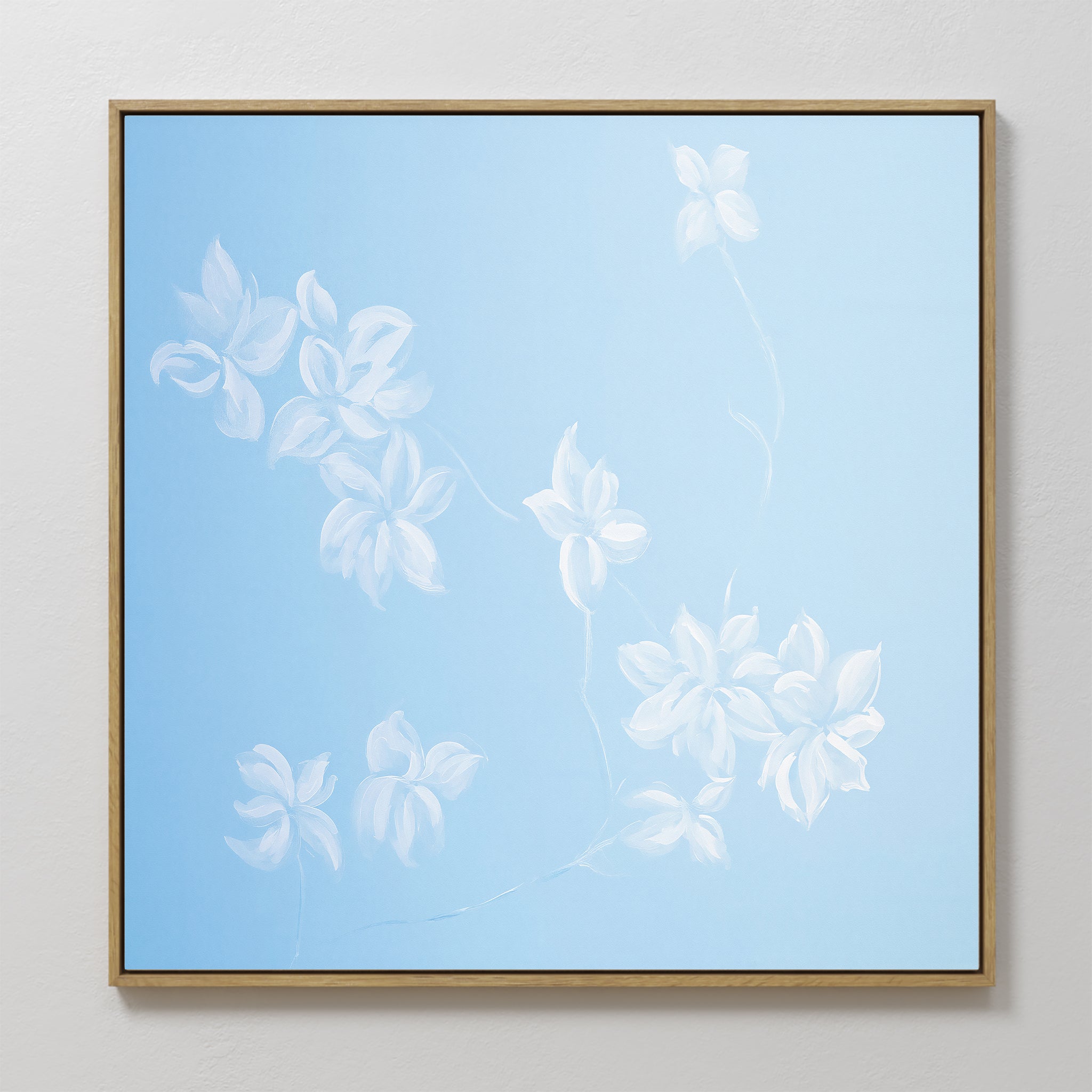 The Gentle Blossoms Canvas Art - Square features delicate white floral details and leaves on a light blue background, framed in thin gold for a soft, airy, and minimalist wall art piece.