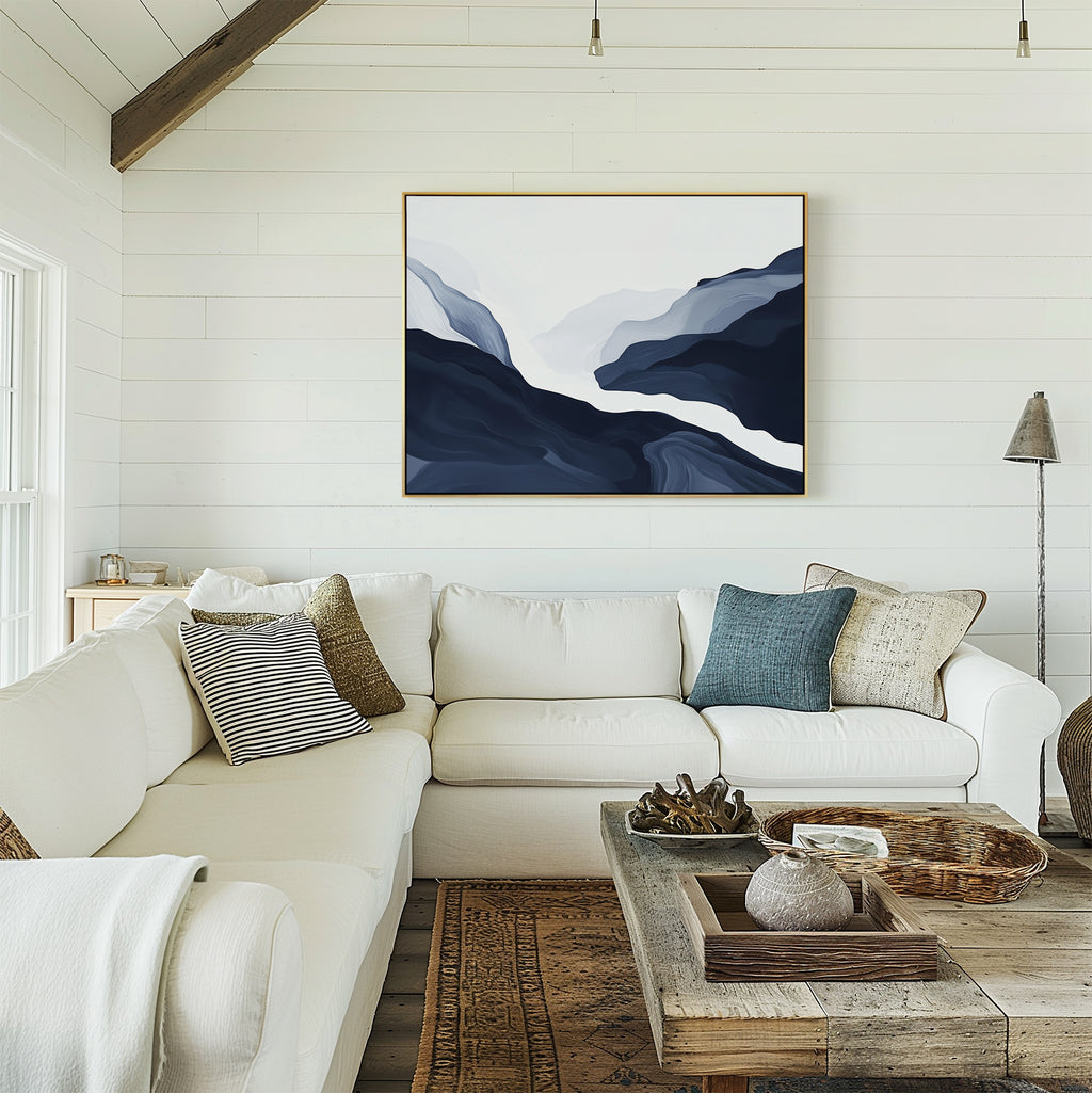A bright, cozy living room with modern decor: a white sectional sofa, assorted pillows, a rustic wooden coffee table, and the Glacier Flow Canvas Art - Horizontal in blue and white on a shiplap wall. Natural light streams in from the left.