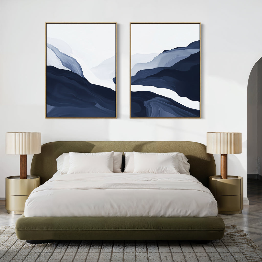 A modern bedroom with a green upholstered bed, white bedding, two beige nightstands with matching lamps, and the Glacier Flow - Set Of 2 abstract blue and white wall art above the headboard brings stylish Nordic flair.