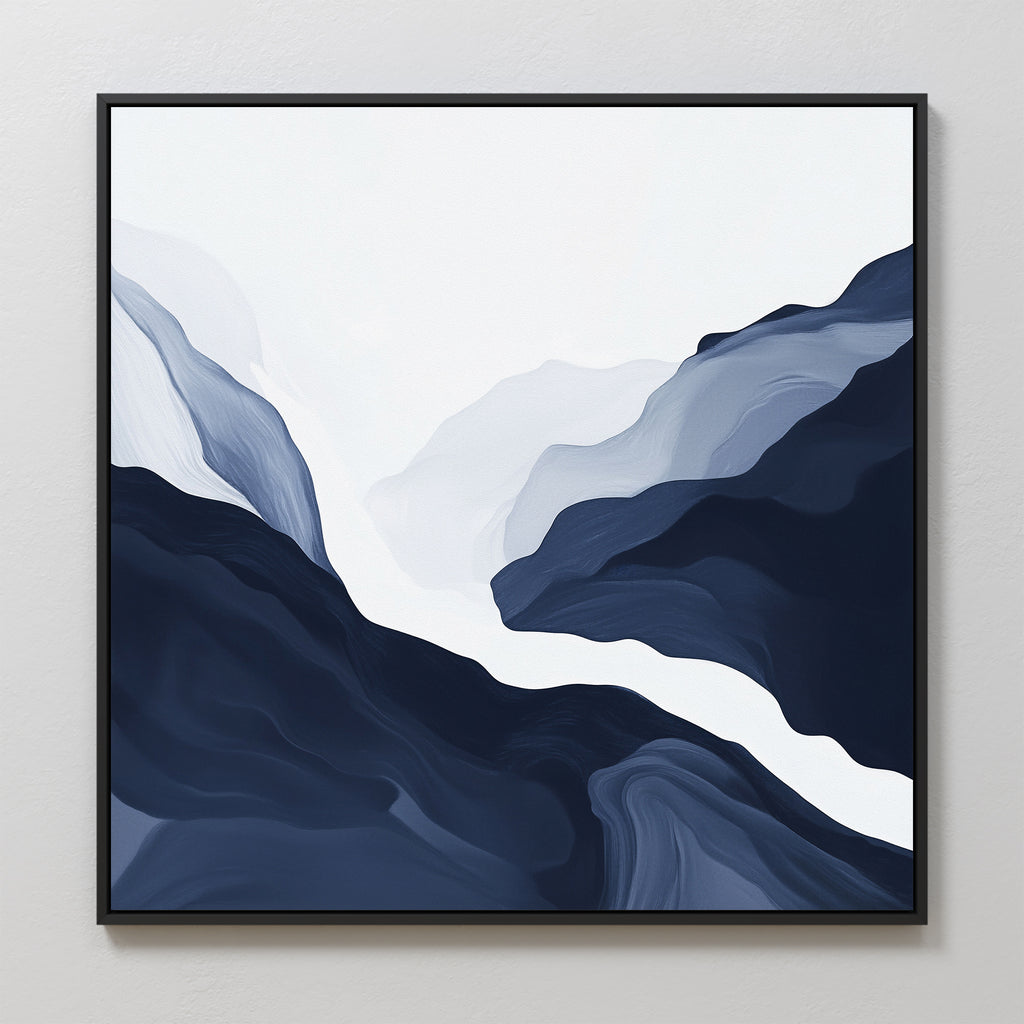 The Glacier Flow Canvas Art - Square showcases layered, flowing shapes in navy blue, gray, and white on a white background. Modern and abstract, it evokes mountains or waves and comes framed in a sleek black frame.