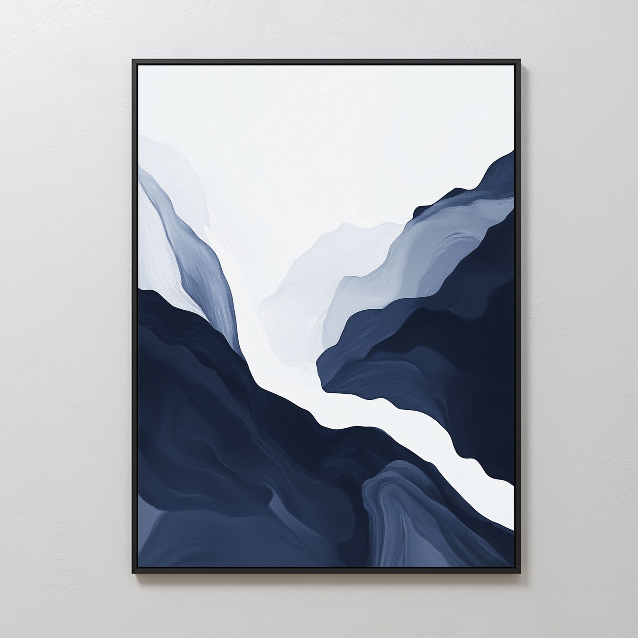 Glacier Flow Canvas Art - Vertical features minimalist abstract navy blue and white shapes like mountains or waves, framed in black for modern home decor, displayed against a light-colored wall.