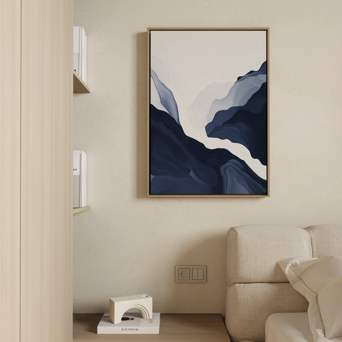 Minimalist living room featuring a light beige sofa, wooden bookshelf of books, and Glacier Flow Canvas Art - Vertical in a wooden frame on a cream wall. A geometric floor decor piece enhances the modern home aesthetic.