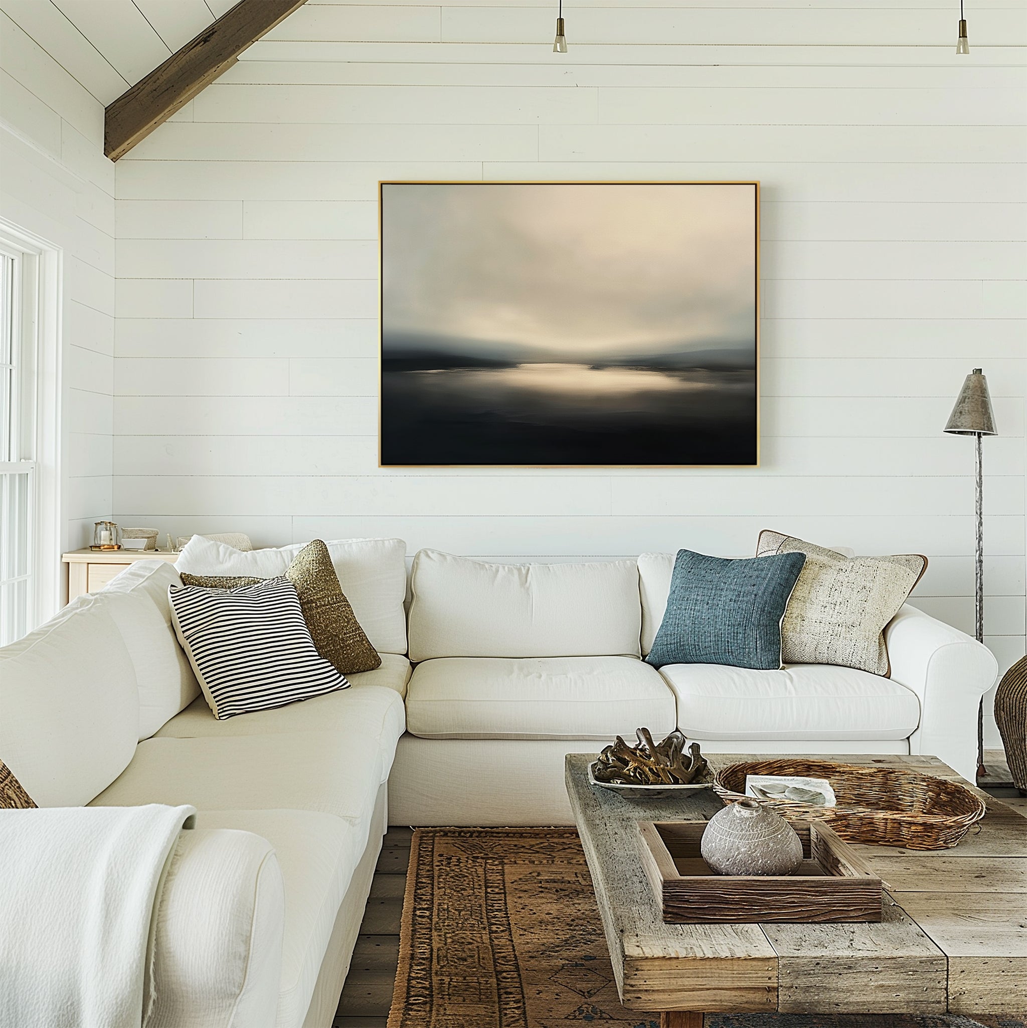 A bright, airy living room with a white sectional, textured pillows, a rustic wooden coffee table, and the Golden Fog Horizon Canvas Art—an abstract landscape—on a shiplap wall. Natural light streams in from the left.