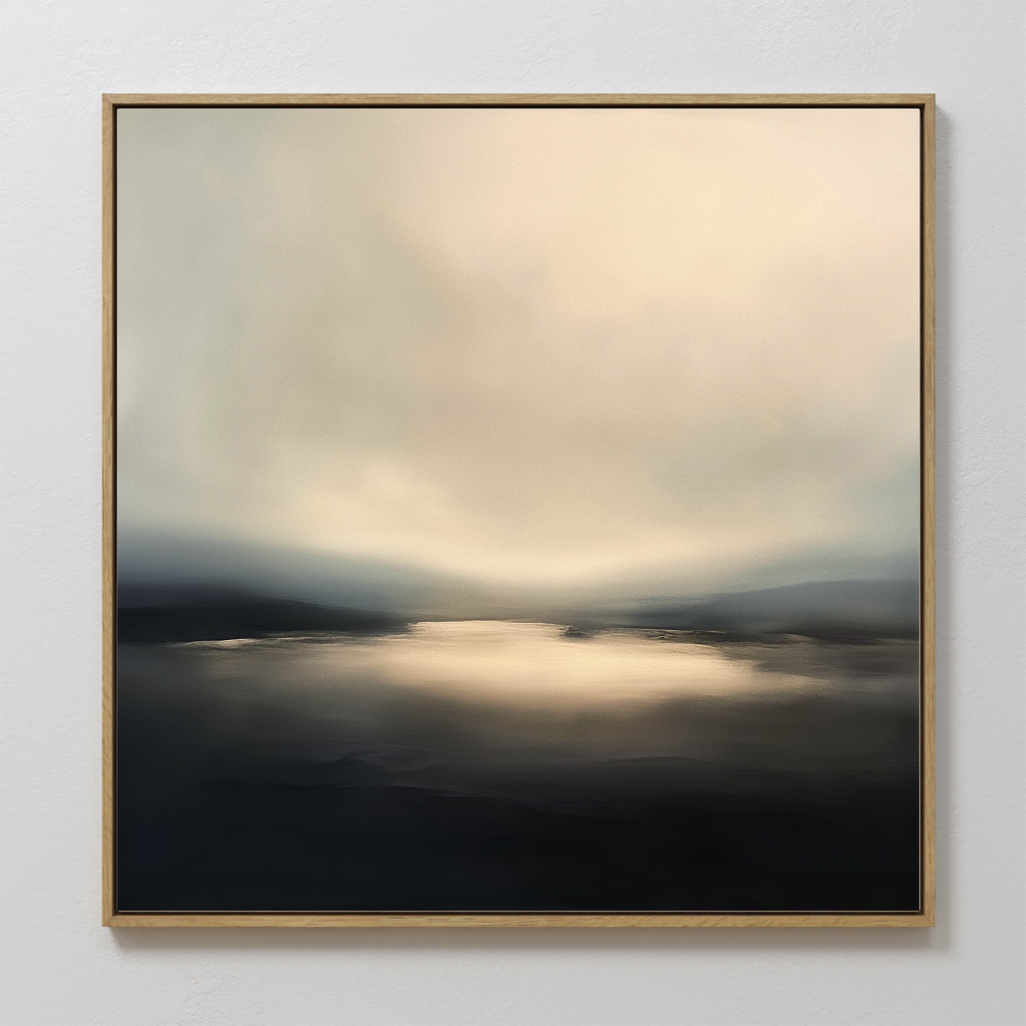 The Golden Fog Horizon Canvas Art - Square features a framed abstract landscape with soft, blurred tones of pale gold, gray, and black, evoking light on water under a misty sky in a serene coastal style.
