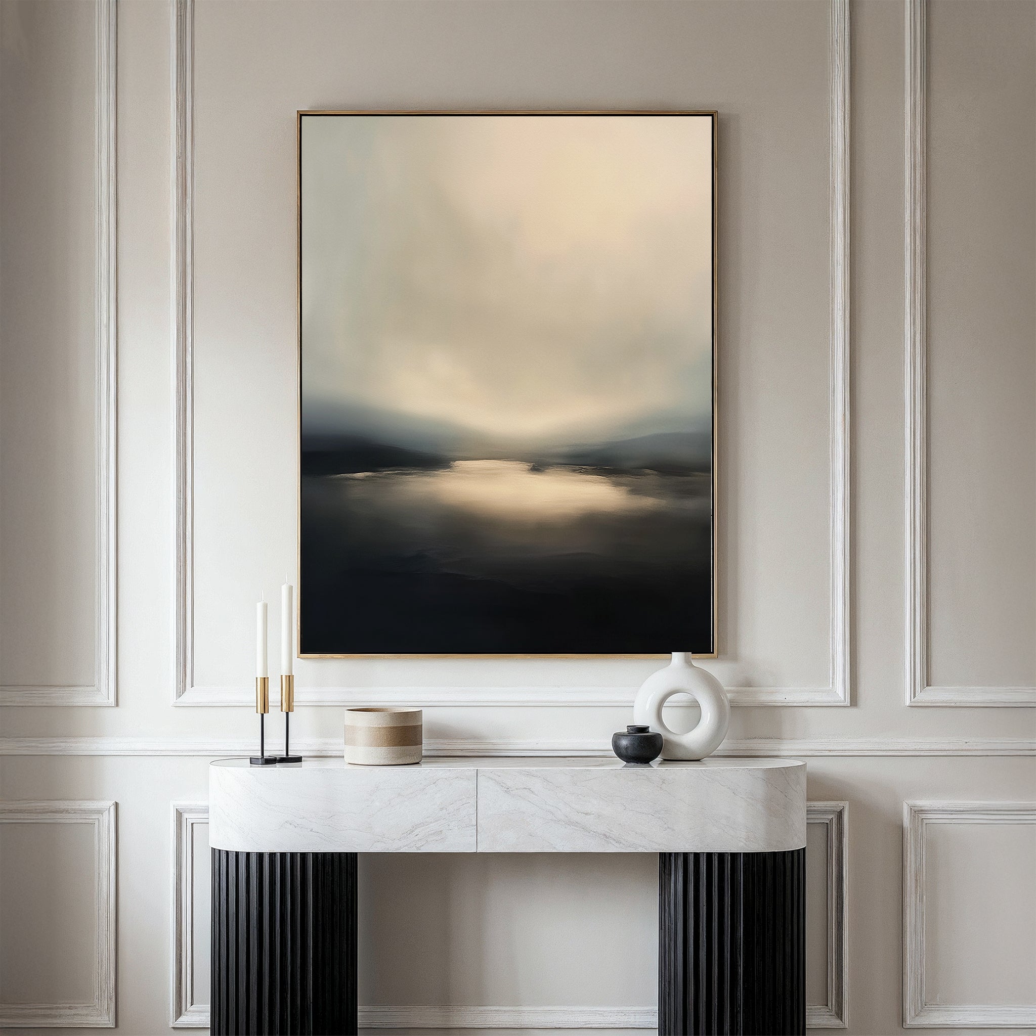 The Golden Fog Horizon Canvas Art - Vertical, with its large moody landscape and muted tones, hangs above a modern console table featuring a white marble top, black legs, and minimalist vases and candles.