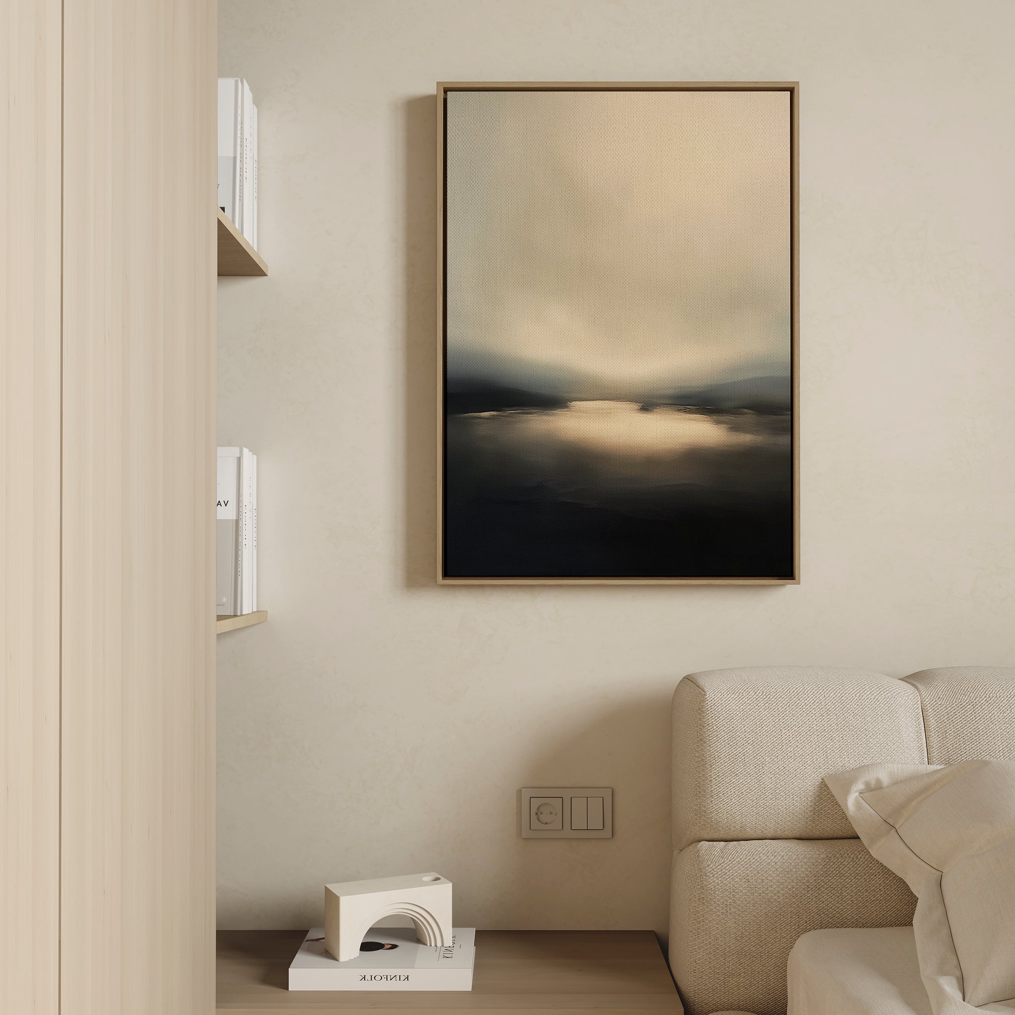 Minimalist living room with a beige sofa, light wood wall and shelves, a small geometric sculpture, and the Golden Fog Horizon Canvas Art - Vertical in soft beige and dark tones hanging above the couch.