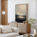 A modern living room with light wood furniture, a soft beige sofa, books, decorative vases on a sideboard, a round floor lamp, a small leafy plant, and the Golden Fog Horizon Canvas Art - Vertical creates an inviting space.