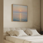 A minimal bedroom features a beige upholstered bed with white pillows. Above, the Golden Reflection Canvas Art - Square adds calming hues, while neutral walls and soft lighting create a tranquil, inviting retreat.