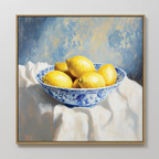Golden Fruit Canvas Art features a blue and white patterned bowl of yellow lemons on a draped cloth, set against a textured blue and yellow backdrop—ideal rustic kitchen decor and charming lemon wall art.