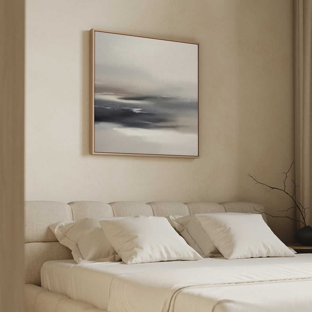 A minimalist bedroom features a beige upholstered bed with white bedding, accented by the Grey Ripples Canvas Art - Square above the headboard. A bare branch in a vase on the bedside table adds to the serene, modern vibe.