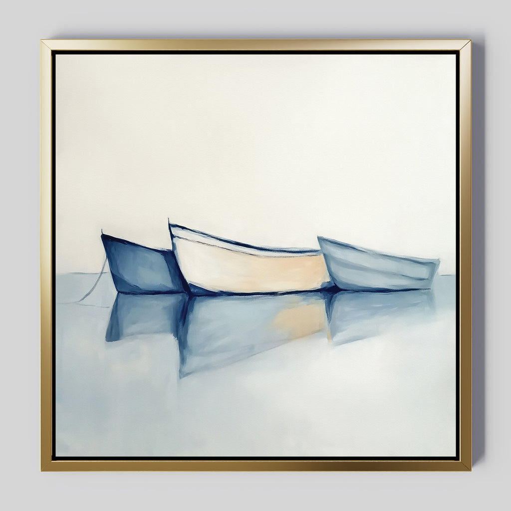 The Harbor Rest Canvas Art - Square features three minimalist rowboats—blue, white, and light blue—on tranquil water with gentle reflections. Displayed in a gold frame, it’s ideal coastal wall decor for a calming touch to any light-toned room.