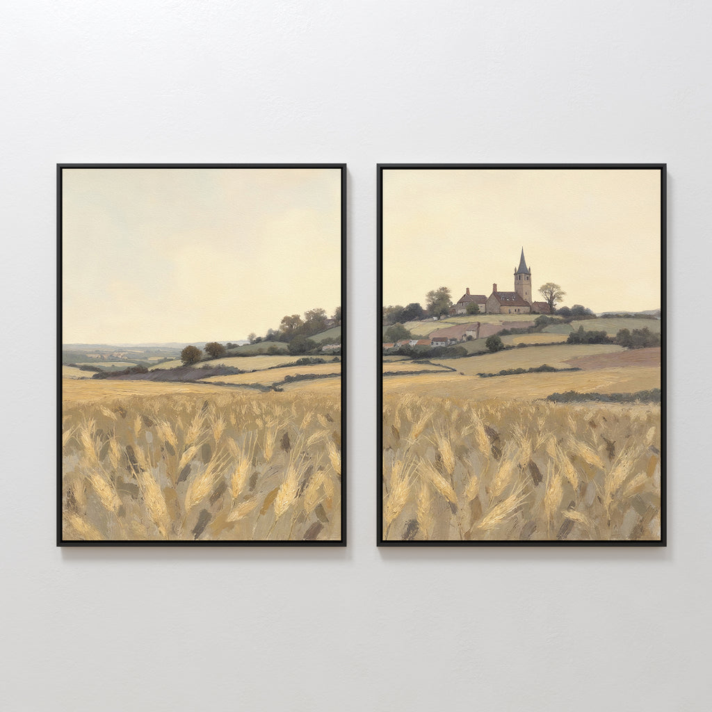 The Harvest Chapel - Set of 2 features framed canvas prints showing a golden wheat field, rolling hills, and a distant village with a church steeple, all beneath a pale sky that flows seamlessly across both prints.