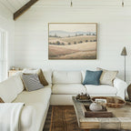 A bright, cozy living room with a white sectional sofa, assorted throw pillows, a rustic wooden coffee table, and the Harvest Fields Canvas Art - Horizontal displayed on a white shiplap wall.