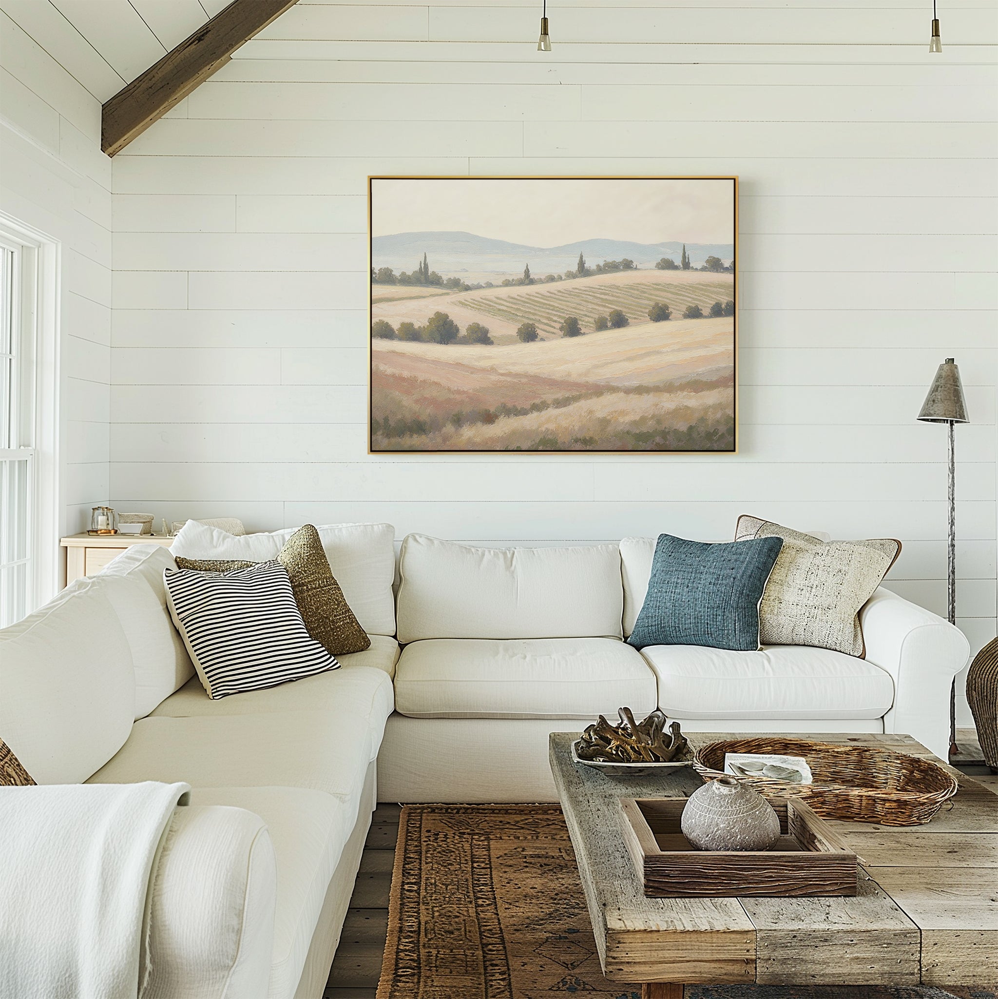 A bright, cozy living room with a white sectional sofa, assorted throw pillows, a rustic wooden coffee table, and the Harvest Fields Canvas Art - Horizontal displayed on a white shiplap wall.