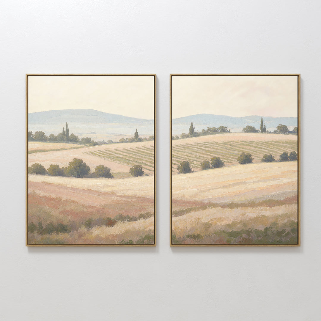 Harvest Fields - Set of 2 features framed paintings of sunlit countryside landscapes with rolling hills and trees in earthy tones—ideal wall art for adding serene farmhouse decor to any white wall.