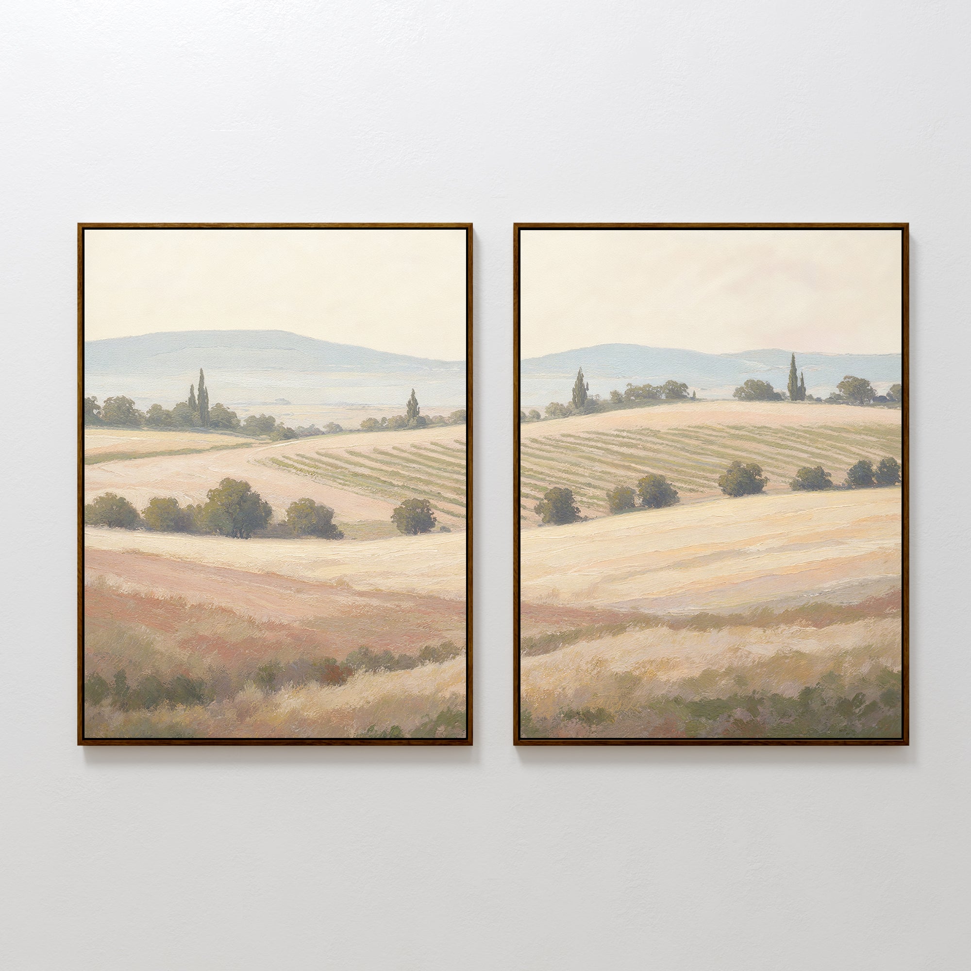 The Harvest Fields - Set of 2 features framed paintings of a serene countryside with rolling hills, fields, and distant mountains in soft, muted colors—ideal wall art for adding a tranquil touch to your space.