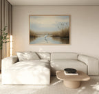 A modern living room with a beige sectional, a light wood coffee table, and the Heron's Morning Canvas Art - Horizontal above the sofa. Soft natural light enhances the serene atmosphere.
