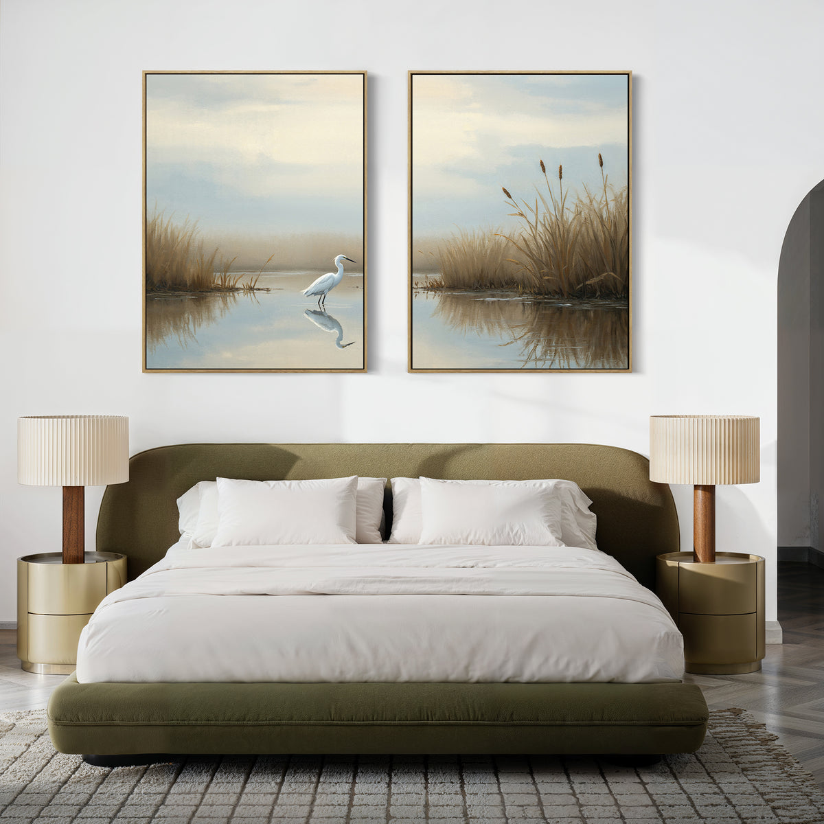 A modern bedroom with an olive-green bed, white bedding, two beige nightstands with matching lamps, and the "Heron's Morning - Set Of 2" wall art above the bed depicting a white egret and a wetland scene.
