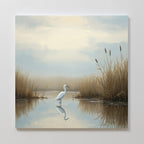 The Heron's Morning Canvas Art - Square features a white egret standing in shallow water among tall grasses and cattails, with its reflection shimmering on the calm surface in soft, muted colors.