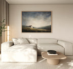A modern living room with a light beige sectional, wooden coffee table, sheer curtains, and the Highland Solitude Canvas Art - Horizontal depicting moody landscape and rustic tranquility on a pale wall.