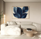 A modern living room features a light beige sectional sofa, low wooden coffee table, potted plant, and the Indigo Depths Canvas Art - Horizontal as elegant wall art on a neutral wall.