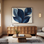 A modern living room with a beige sofa, wooden coffee table, and sideboard. The Indigo Depths Canvas Art - Horizontal hangs above the sideboard, while a small vase of flowers sits on the table. Warm lighting fills the space.