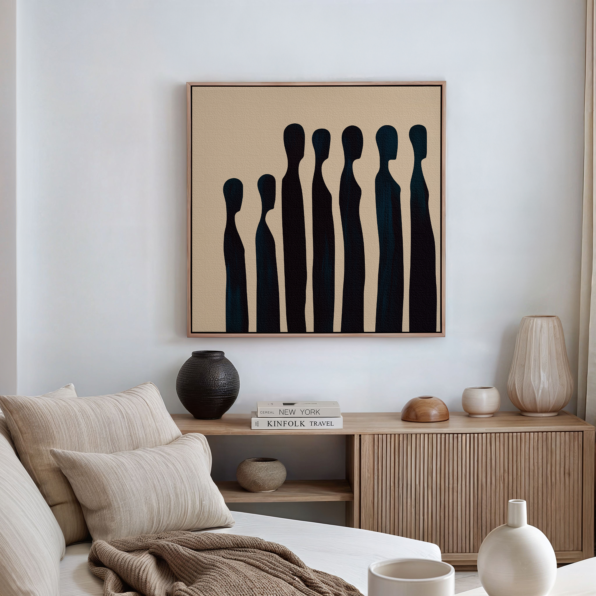 A modern living room with a beige sofa, patterned cushions, wooden sideboard, ceramic vases, books, and minimalist Indigo Profile Abstract Canvas Art—perfect for stylish decor.