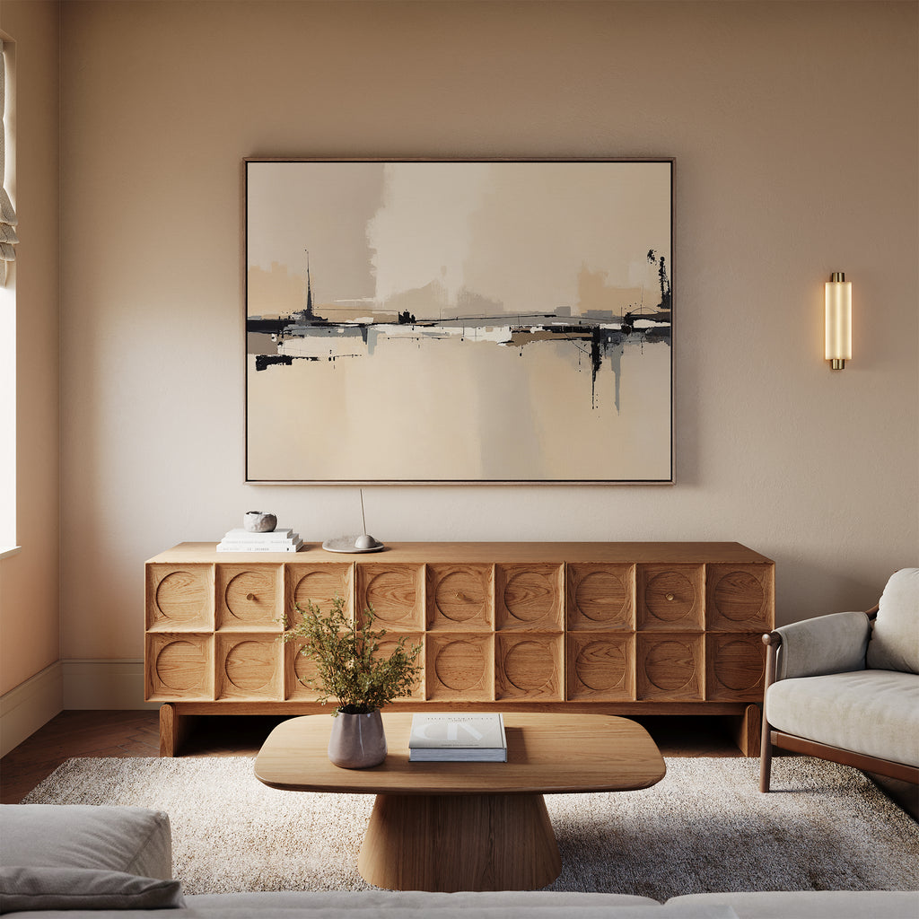 A modern living room with neutral tones features a wooden sideboard, the Industrial Cityscape Canvas Art - Horizontal above it, a low coffee table, a plush rug, and a light beige sofa.