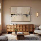 A modern living room with neutral tones features a wooden sideboard, the Industrial Cityscape Canvas Art - Horizontal above it, a low coffee table, a plush rug, and a light beige sofa.