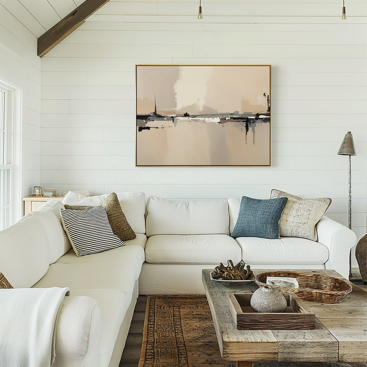 A cozy living room with a white sectional sofa, assorted pillows, a rustic wooden coffee table with decor, floor lamp, and Industrial Cityscape Canvas Art - Horizontal on the white shiplap wall. Natural light streams in from the left.