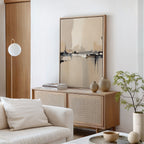 A modern living room in neutral tones showcases the Industrial Cityscape Canvas Art - Vertical, a light wood sideboard with vases and books, abstract wall art, a white sofa with cushions, a round coffee table, potted plant, and floor lamp.