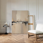 The Industrial Cityscape Canvas Art - Vertical leans against a white paneled wall on a herringbone wood floor, with a cushioned wooden chair and round table nearby for a minimalist, cozy modern living room vibe.