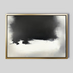 Ink Cloud Formation Canvas Art - Horizontal features a large black area blending into white and gray tones, set in a gold frame on a light gray background. Its soft transitions and minimalistic style create modern sophistication.