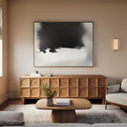 A modern living room with a wooden coffee table and sideboard, beige walls, a light sofa, the Ink Cloud Formation Canvas Art - Horizontal as a statement piece, a wall sconce, and fresh flowers in a vase on the table.