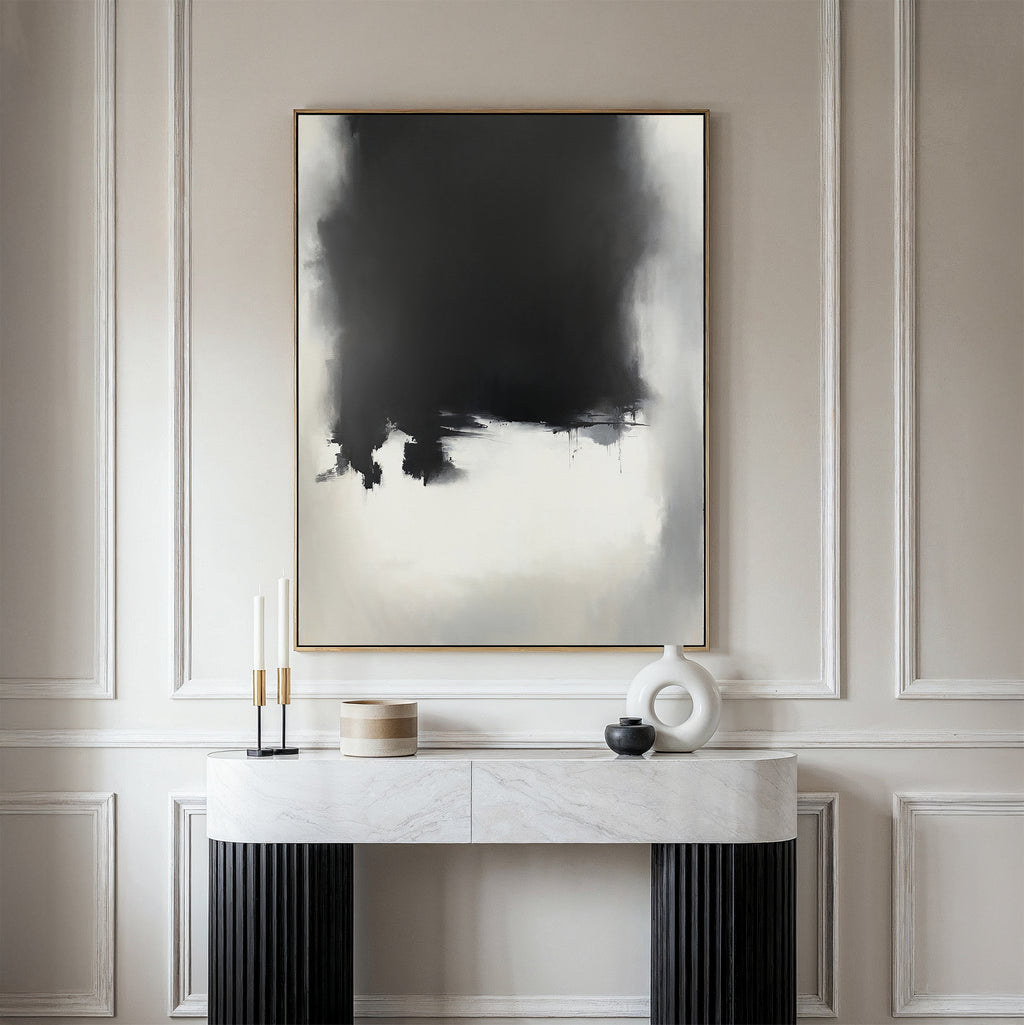 A minimalist entryway features a marble console table, decorative objects, and the Ink Cloud Formation Canvas Art - Vertical on a wall with elegant panel molding for a touch of modern sophistication.
