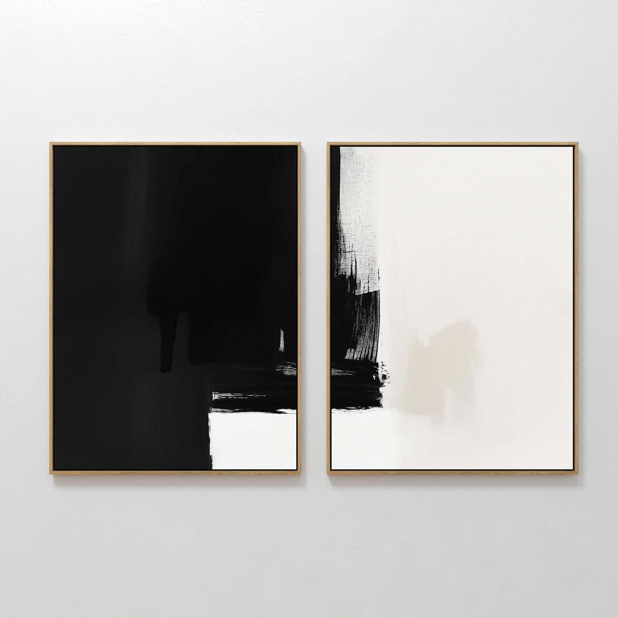 The Ink Divide - Set Of 2 features two minimalist wall art prints: one mostly black with white at the base, the other showing bold black brushstrokes on white. Both are framed in slim gold, adding a touch of modern elegance.