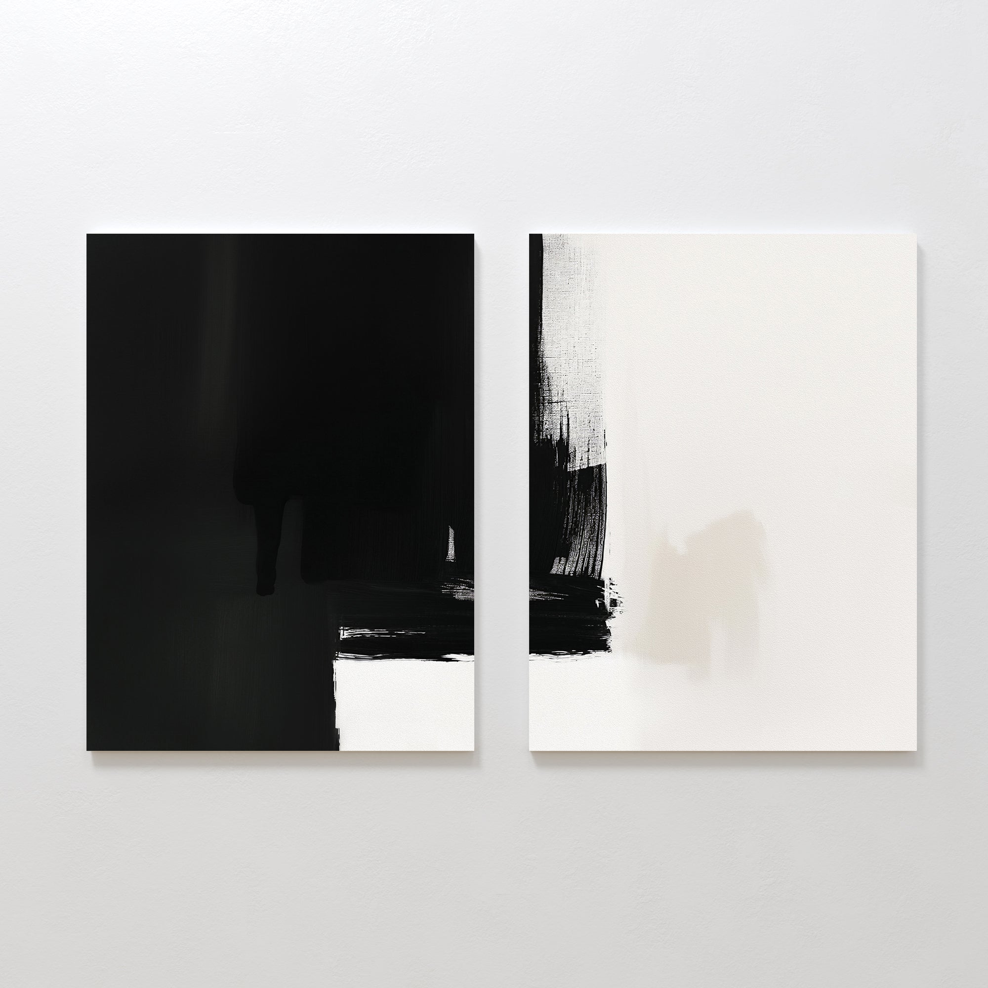 Ink Divide - Set Of 2 features minimalist abstract prints: the left is a mostly black canvas with bold white strokes at the bottom, while the right is predominantly white with striking black brushstrokes in the upper left corner.