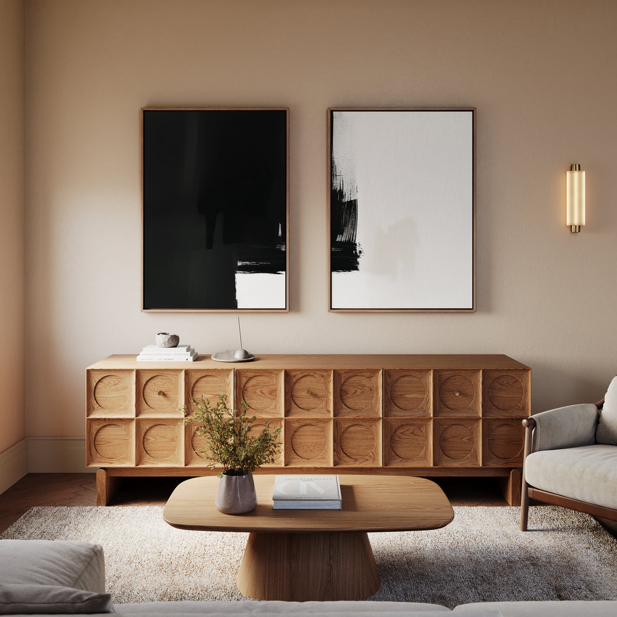 A modern living room with a wooden sideboard featuring geometric patterns, the Ink Divide - Set Of 2 contemporary wall art above it, a coffee table with a book and vase, and a light-colored armchair on a textured rug.