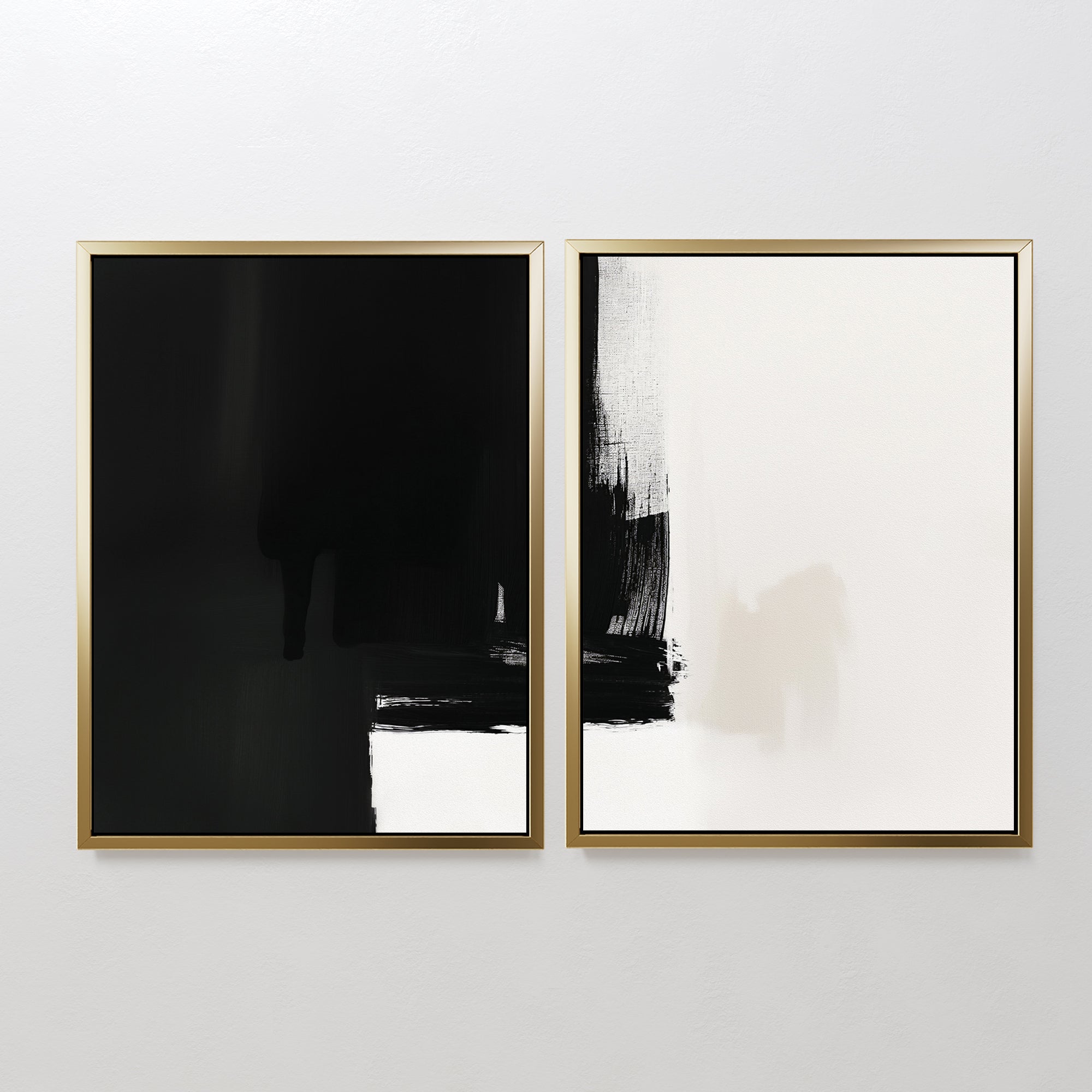 The Ink Divide - Set Of 2 features minimalist wall art: two framed abstract prints, one with a black upper section and white below, the other with bold black brushstrokes on a mainly white background, hung side by side on a white wall.