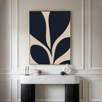 Minimalist living room decor features the Botanical Ink Abstract Canvas Art—a framed piece with bold navy and beige curves—above a white marble console. Modern vases and candles accent the space, complemented by elegant wall molding.