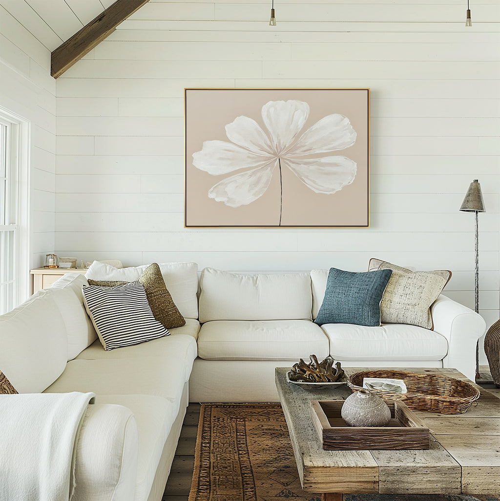 A living room with a large couch and neutral wall decor, featuring the Ivory Bloom Canvas Art - Horizontal above the sofa.