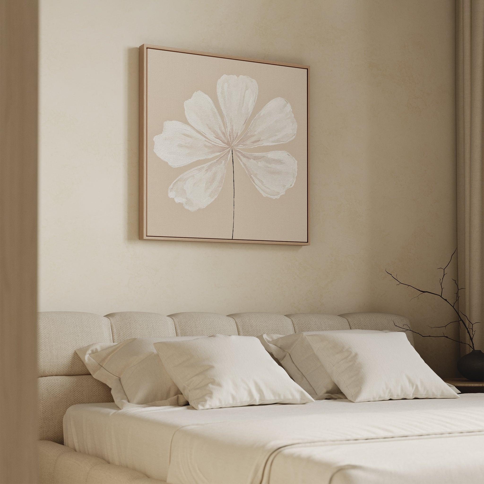 A neutral-toned bedroom features a beige upholstered bed, white bedding, and the Ivory Bloom Canvas Art - Square above the headboard. A bare branch in a vase adds a final touch of neutral decor to the bedside table.
