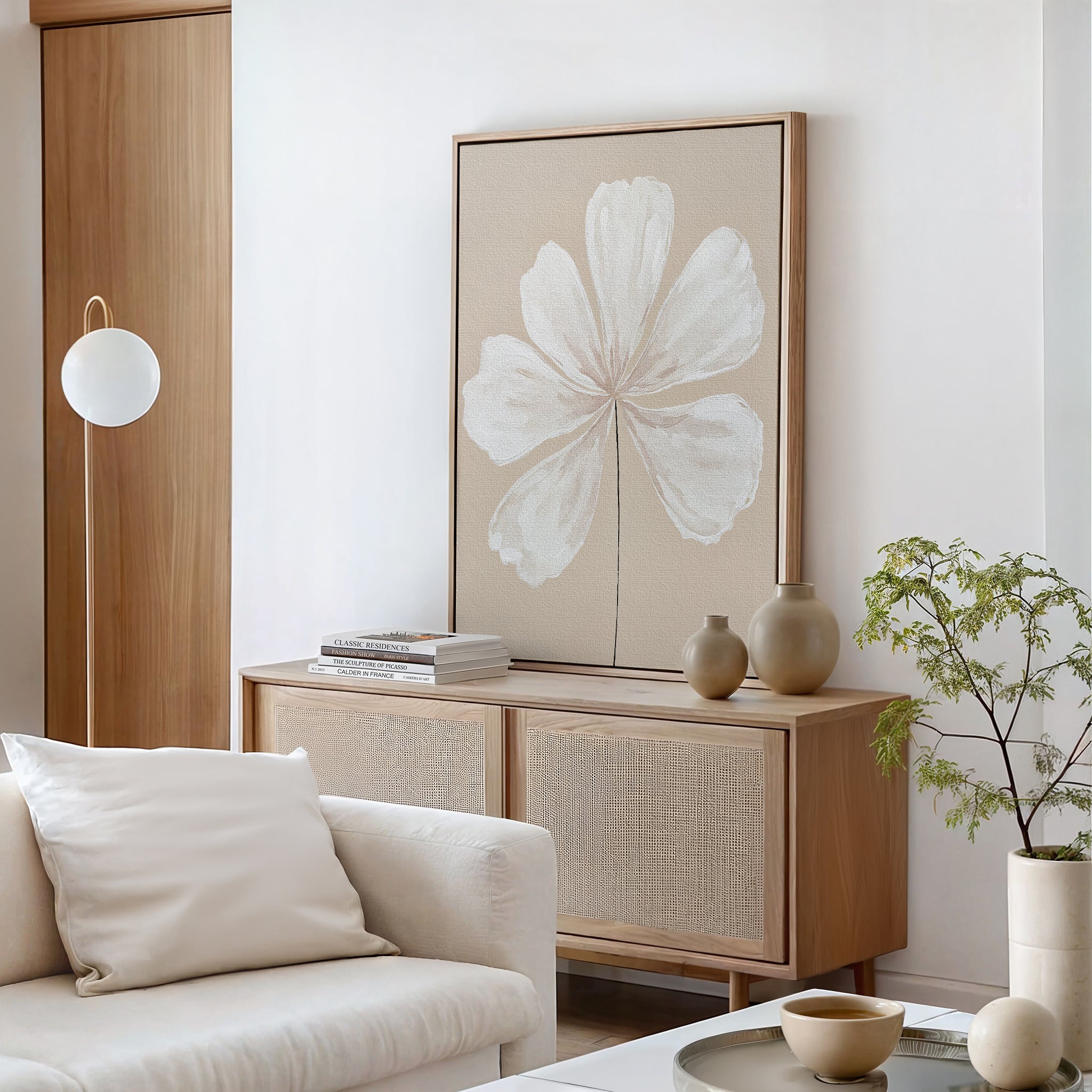 Minimalist living room with a light wood sideboard, Ivory Bloom Canvas Art - Vertical as striking wall art, ceramic vases, potted plant, round paper lamp, and a neutral sofa with a cream pillow—ideal for contemporary neutral decor lovers.