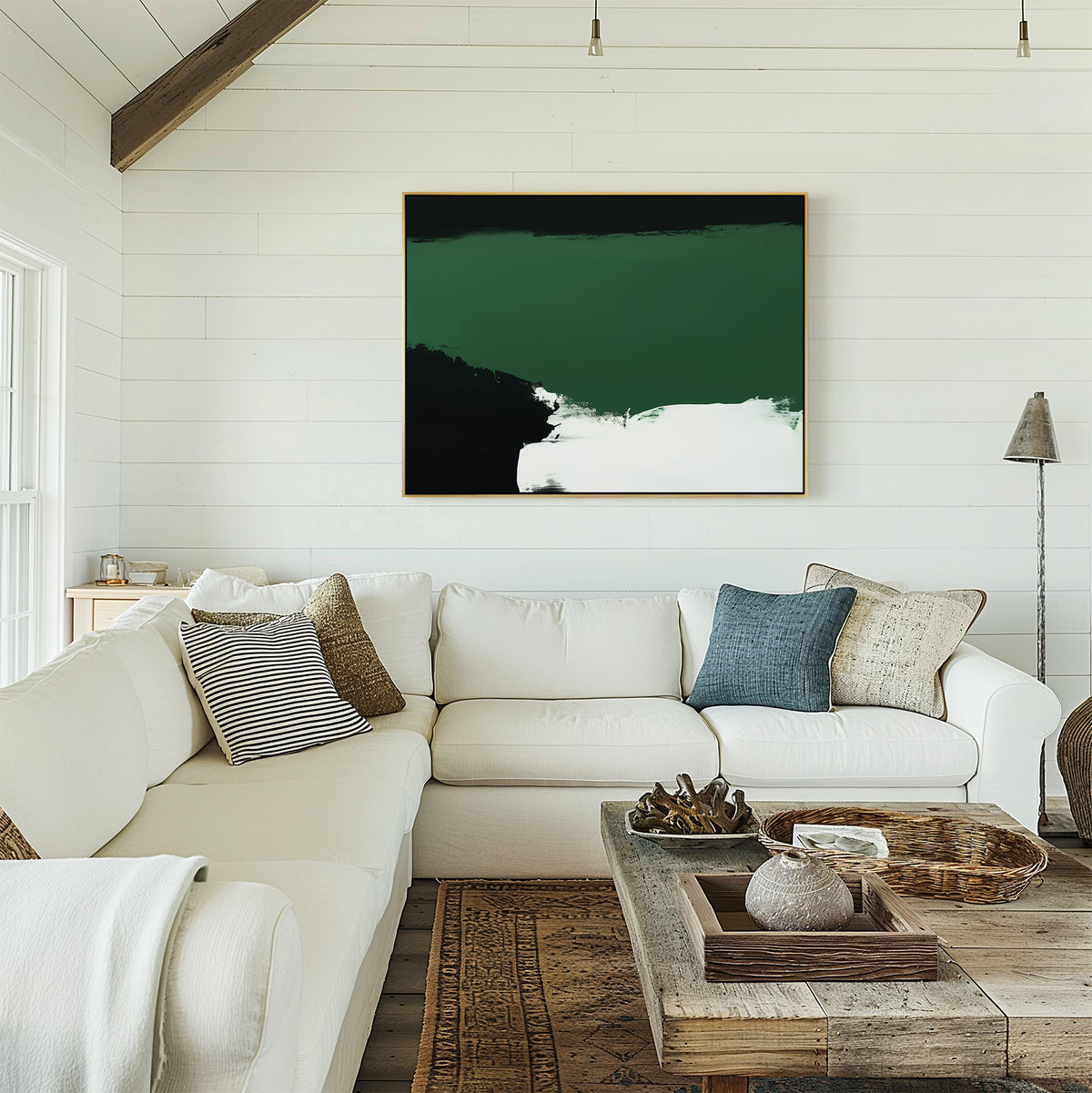 A cozy living room with a white sectional sofa, assorted pillows, a rustic wooden coffee table, and the Jade Depths Canvas Art - Horizontal in green, black, and white tones hanging on a shiplap wall.