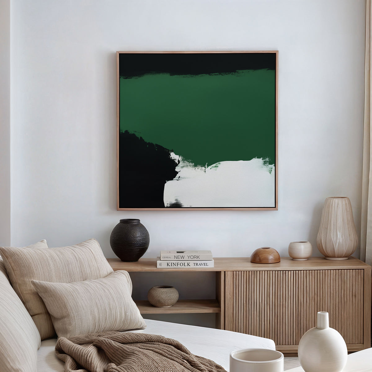 A modern living room with a beige sofa, neutral cushions, wooden sideboard, vases, and books is elevated by the Jade Depths Canvas Art - Square—its bold black and white design makes it the stunning focal point of this stylish space.